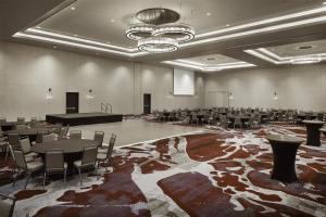 a large room with tables and chairs and a piano at Embassy Suites Amarillo Downtown in Amarillo +34 photos