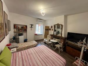 a bedroom with a bed and a television and a table at Room Saronno + B&B in Saronno