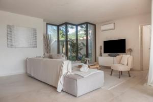 a white bedroom with a bed and a chair at La Villa in Illes Balears