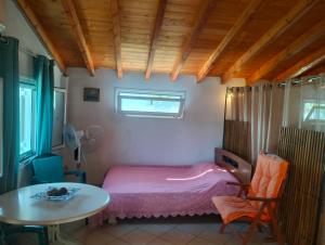 a bedroom with a pink bed and a table at Greeksummer in Edipsos