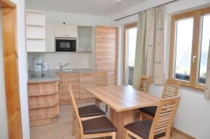 RossleithenにあるFerienhof Bergerのキッチン、ダイニングルーム(木製のテーブルと椅子付)