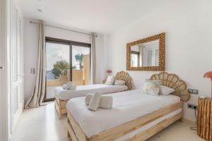 two beds in a room with a mirror and a window at La Villa in Illes Balears +24 photos