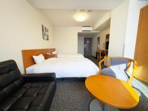 a hotel room with a bed and a couch at Hotel Route-Inn Niihama in Niihama +26 photos