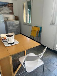 a kitchen with a wooden table and a white chair at Cà Bartolomeo in Finale Ligure