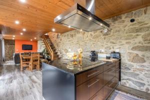 a kitchen with a stone wall and a stove at Casa De Pedra D'alborinhas in Arões