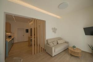 ein Wohnzimmer mit Sofa und Tisch in der Unterkunft Corali 2 - Coastal Retreat in Katakolo