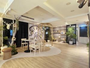 a room with a table and chairs and plants at Finders Hotel Hualien Wen Hua in Hualien City