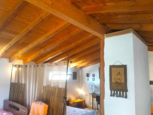 a room with wooden ceilings with a bed and a desk at Greeksummer in Edipsos