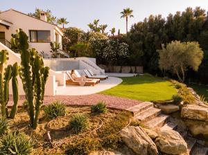 a garden with a cactus and a house at Villa Kahuna Sotogrande in Sotogrande