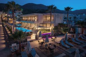 a hotel with a pool and chairs and umbrellas at Riviera Boutique Hotel in Stalís