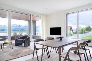 a living room with a table and chairs and a television at Rigi Lakeside Apartments in Merlischachen