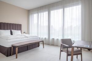 a bedroom with a bed and a table and a chair at Rigi Lakeside Apartments in Merlischachen