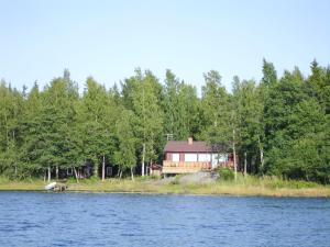 a house on the shore of a lake with trees at Villa Sundet in Svartön