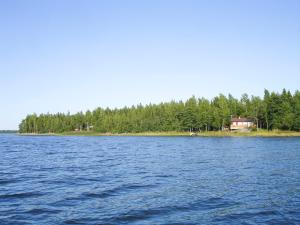 a large body of water with a house and trees at Villa Sundet in Svartön +2 photos