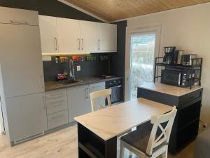 a kitchen with white cabinets and a table with a microwave at Tiny House Milena in Greifswald