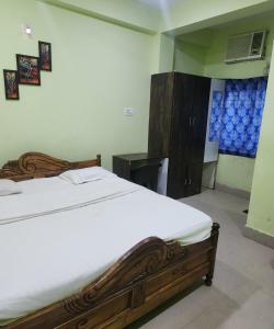 a bedroom with a large wooden bed and a desk at SWAYAMSIDDHA continental in Kendrāparha