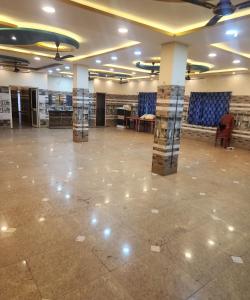 a large room with columns and blue chairs in it at SWAYAMSIDDHA continental in Kendrāparha