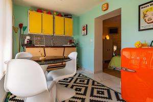 a kitchen with white chairs and an orange refrigerator at La Maison Pop avec Piscine Privée in Romans-sur-Isère