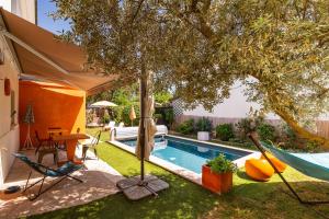 a backyard with a pool with a tree and a hammock at La Maison Pop avec Piscine Privée in Romans-sur-Isère