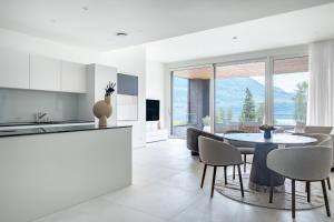a kitchen and dining room with a table and chairs at Rigi Lakeside Apartments in Merlischachen