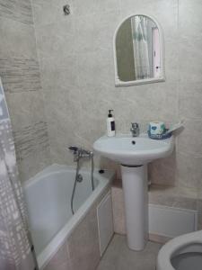 a bathroom with a sink and a toilet and a bath tub at Циолковского с кодовым замком in Oral +9 photos