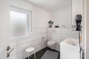 a white bathroom with a toilet and a window at Ferienhaus Maag, 102qm in Attendorn +29 photos