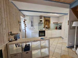 a kitchen with white cabinets and a blue ceiling at penty vero in Plobannalec-Lesconil +8 photos