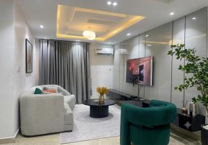 a living room with two chairs and a tv at Three bedroom apartment Magodo GRA in Magodo