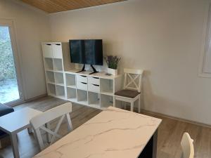 a living room with a flat screen tv on a shelf at Tiny House Milena in Greifswald