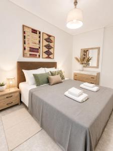 a bedroom with a large bed with two towels on it at Thalassia Pefkias Apartment in Xylokastro