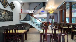 a restaurant with a staircase and tables and chairs at Balcony Superior King - Châu Giang Hotel in Ga Phú Trung