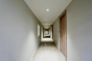 an empty hallway with white walls and wooden floors at Mansions by HomeSlice in Bangalore