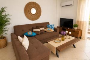a living room with a brown couch and a table at Thalassia Pefkias Apartment in Xylokastro