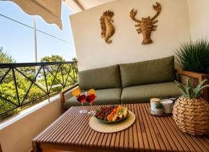a table with a bowl of fruit on a balcony at Thalassia Pefkias Apartment in Xylokastro +12 photos