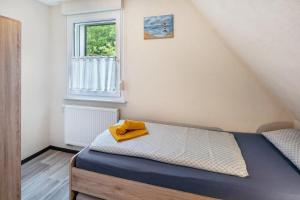 a bedroom with a bed with a yellow towel on it at Ferienhaus Maag, 102qm in Attendorn