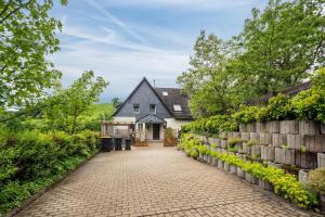 a house with a brick walkway in front of a house at Ferienhaus Maag, 102qm in Attendorn