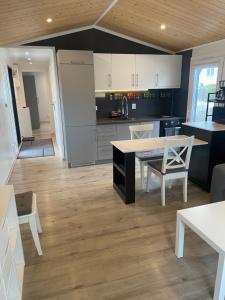 a kitchen with white cabinets and a table and chairs at Tiny House Milena in Greifswald +6 photos
