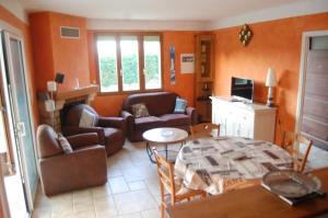 a living room with a couch and a table at La Chênaie Gîte in Sampzon