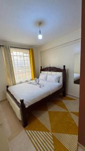 a bedroom with a large bed with a window at Cosy Loft Eldoret in Eldoret
