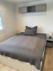a bedroom with a bed with a gray comforter at Tiny House Milena in Greifswald
