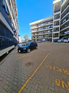 a car parked in a parking lot next to some buildings at Cosy Loft Eldoret in Eldoret