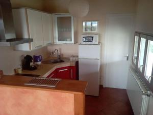 a kitchen with white cabinets and a white refrigerator at La Chênaie Gîte in Sampzon