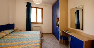 a bedroom with a bed and a desk and a mirror at Hotel Corallo in Pomonte