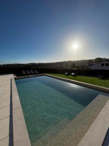 a swimming pool with the sun in the background at Casa Casal da Eva in Alcobaça
