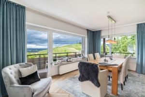 a dining room with a table and chairs and a large window at Baden-Chalet - Panoramablick in Bühl