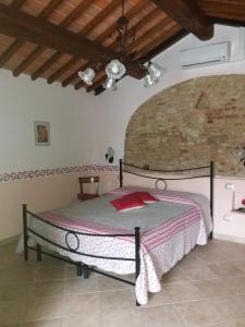 a bedroom with a bed in a room with a stone wall at Antico Casolare in San Gimignano