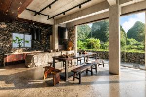 a dining room with a table and benches at The Dragons Rest Sanctuary-Yulong River Branch - Infinity Pool & Cafe - English Speaking Service - Free MTB Rental & Tailor-Made Tour Service in Yangshuo