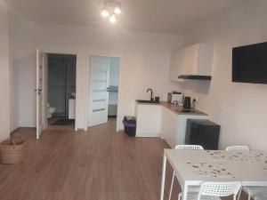 a kitchen and dining room with a table and chairs at Miskant Apartamenty in Stary Karwno