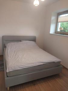 a bed in a white room with a bed frame at Miskant Apartamenty in Stary Karwno