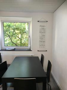 a black table and chairs in a room with a window at H4 Erdgeschoss in Nellingen